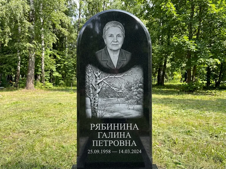 Памятник с гравировкой берёзы: стела с плавным арочным верхом — зимняя берёза, снег на ветвях, газон без ограды, стриженая трава, работа «Рябинина» в Ханты-Мансийске