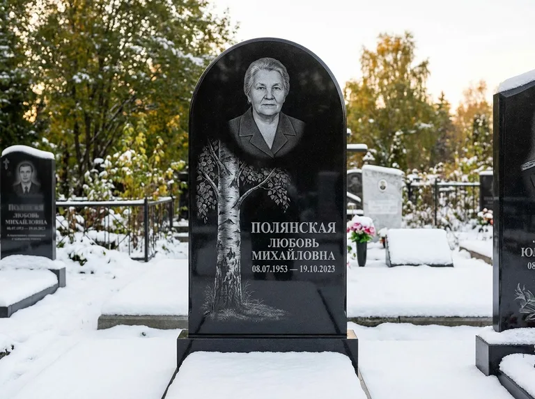 Памятник с гравировкой берёзы: полукруглая стела — объёмная одинокая берёза с фактурной корой, заснеженный зимний участок, работа «Полянская» в Ханты-Мансийске