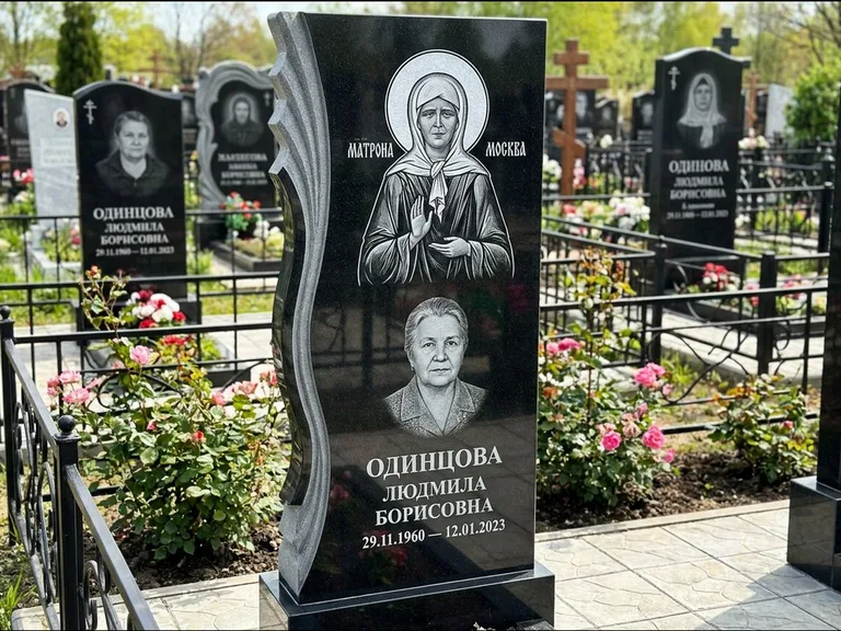 Памятник с гравировкой иконы: ступенчатая двухуровневая стела — Архангел Михаил на стеле, каменная дорожка из плитняка, работа «Одинцов» в Ханты-Мансийске
