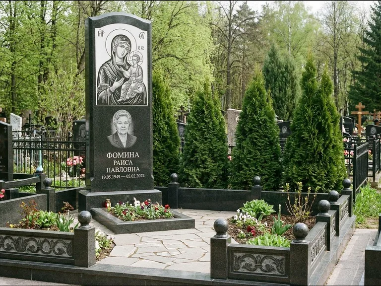 Памятник с гравировкой иконы: высокий гранёный обелиск с крестом-навершием — гравировка образа Матроны Московской, открытый участок без ограды, работа «Третьяков» в Ханты-Мансийске