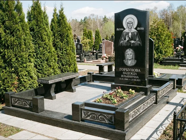 Памятник с гравировкой иконы: стела в форме раскрытой книги с образом — гравировка образа Спасителя, цоколь тёмной плиткой, работа «Зотов» в Ханты-Мансийске
