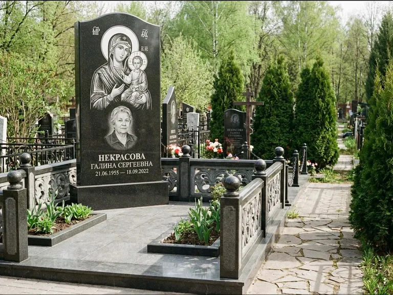 Памятник с гравировкой иконы: полукруглая стела с купольным навершием — Архангел Михаил на стеле, заснеженный зимний участок, работа «Гущин» в Ханты-Мансийске