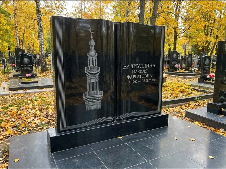 Мусульманский памятник с гравировкой мечети: стела в форме раскрытой книги на подставке — белая гравировка силуэта мечети с минаретами, цоколь тёмной плиткой, работа «Исмаилова» в Ханты-Мансийске