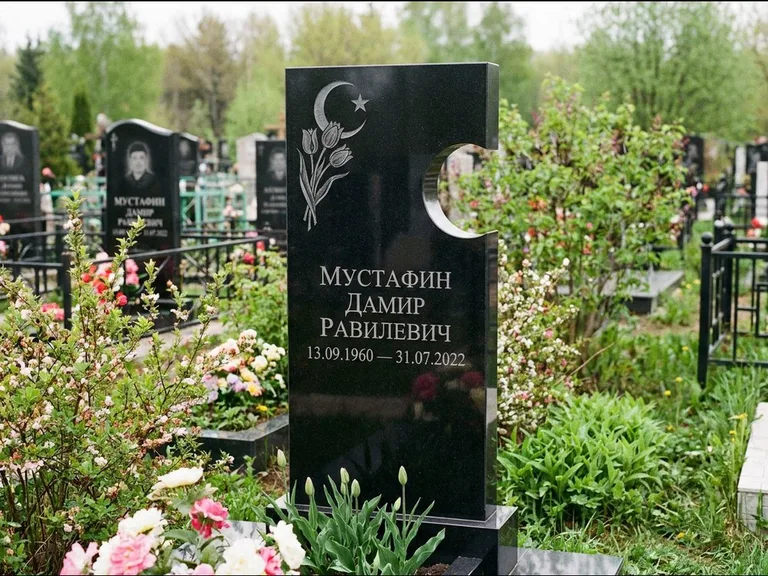 Мусульманский памятник: стела с боковым вырезом в форме полумесяца — гравировка минарета с полумесяцем, низкие кусты в цвету, работа «Мустафин» в Ханты-Мансийске