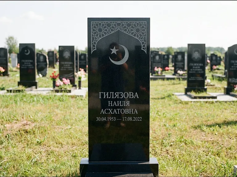 Мусульманский памятник: узкая вертикальная стела-пилон с полумесяцем — гравировка мечети в михраб-арке с орнаментом, открытая лужайка без ограды, работа «Ибрагимова» в Ханты-Мансийске