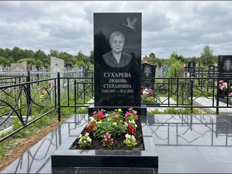 Памятник с гравировкой журавлей — гравировка одиночного летящего журавля над портретом, работа «Сухарева» в Ханты-Мансийске