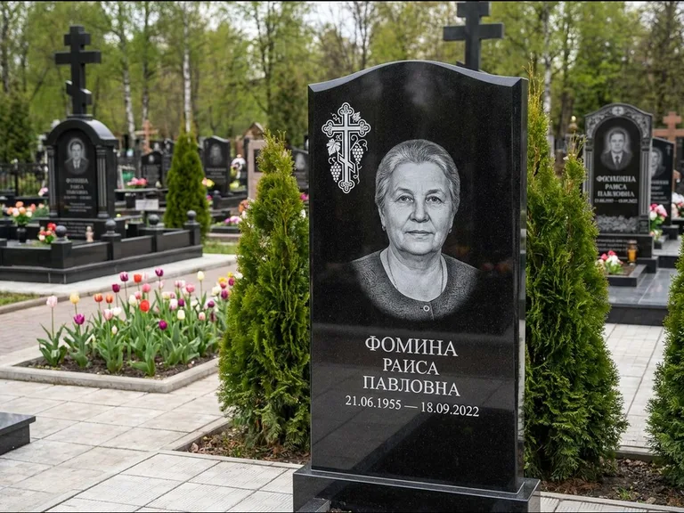 Памятник из чёрного гранита — двухцветная стела с крестом с распятием, работа «Одинцова» в Ханты-Мансийске