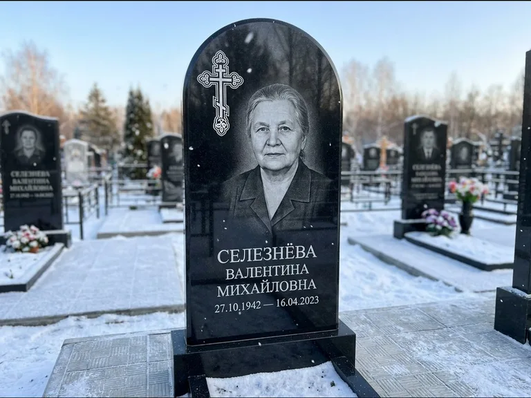 Памятник из чёрного гранита — массивная стела с крестом в лучах с крестом в лучах, работа «Одинцова» в Ханты-Мансийске
